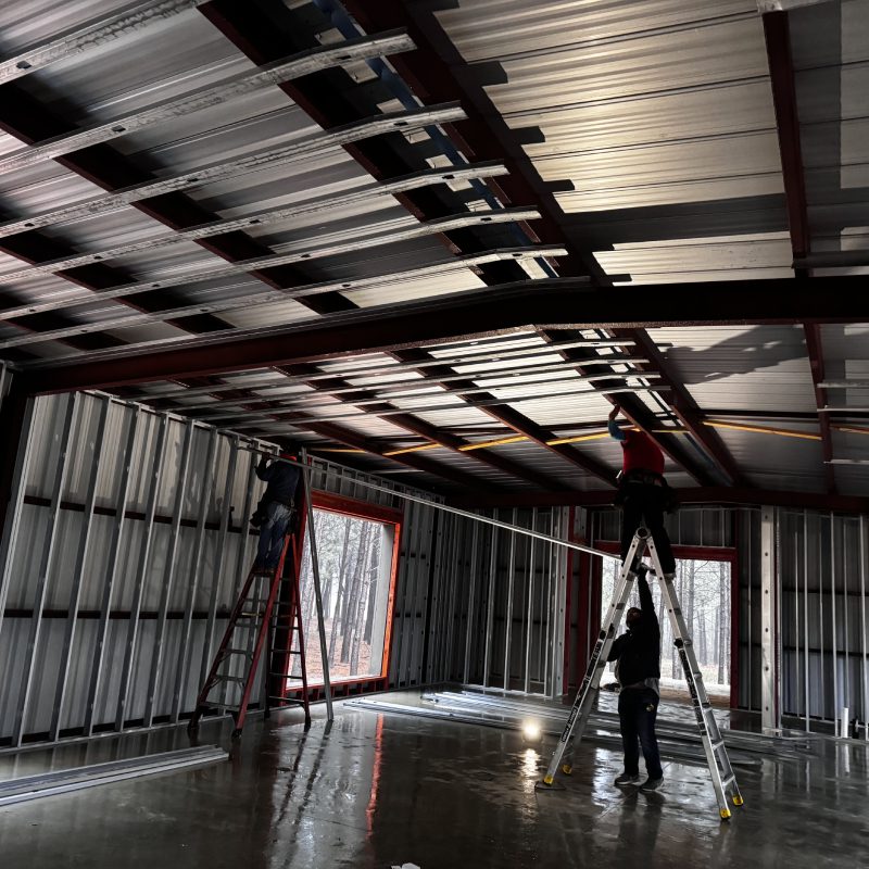 A man working on a roof in a building, diligently carrying out his tasks with precision and focus.