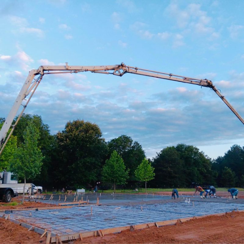 Construction site with crane moving concrete.