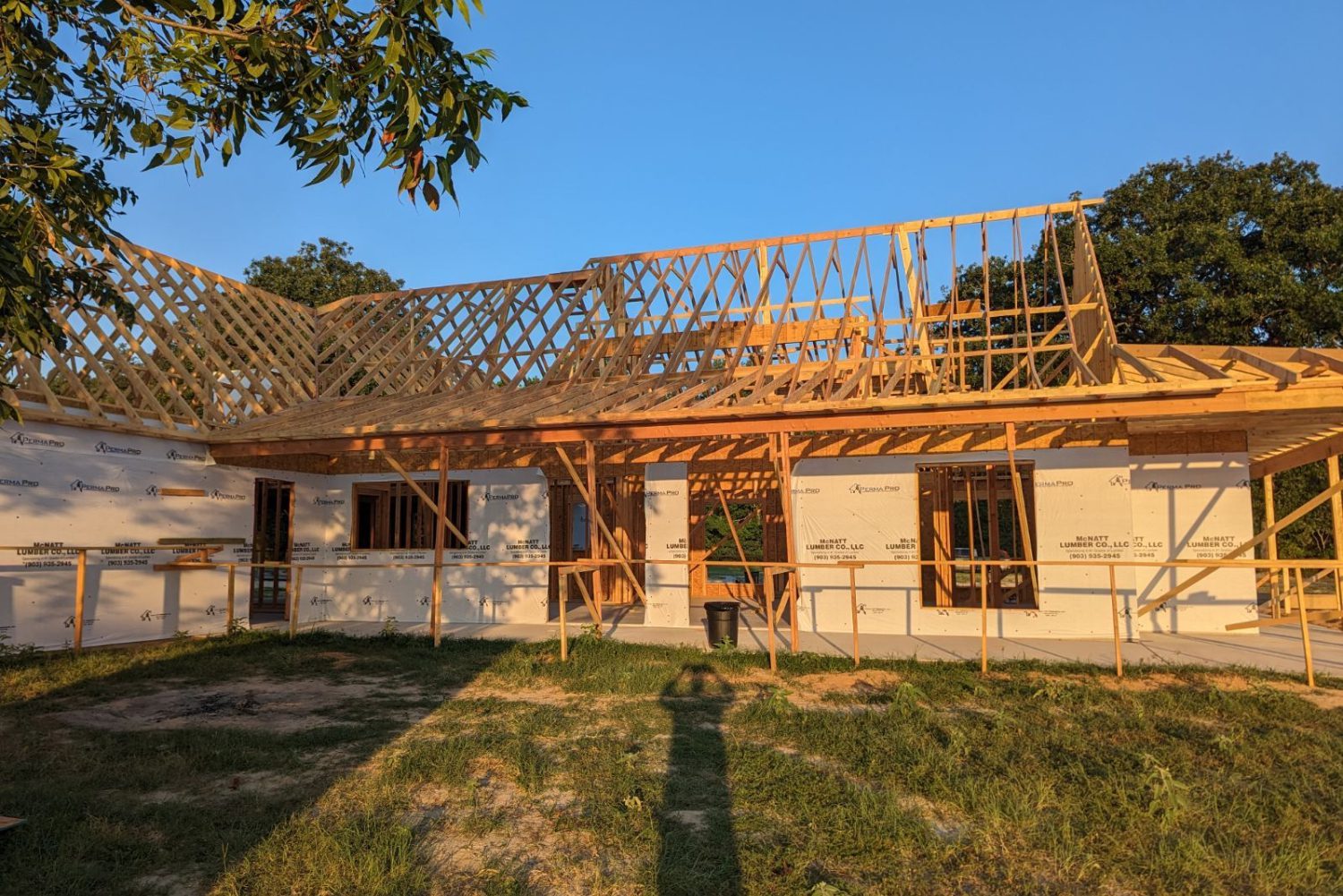 A house under construction with scaffolding, workers, and building materials.</p>
<p>