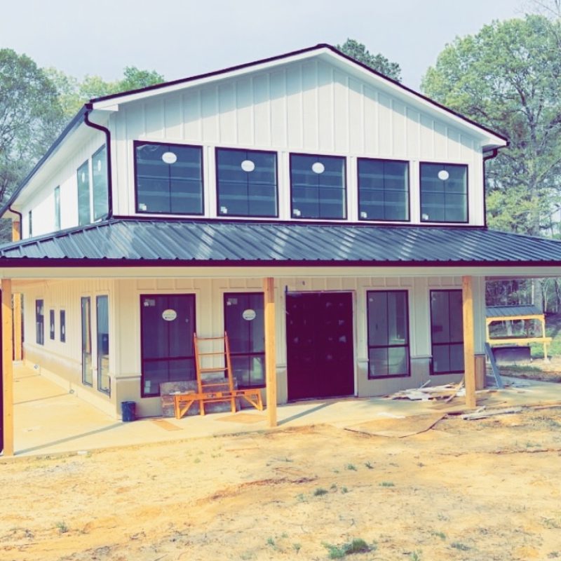  A house under construction surrounded by trees in a wooded area.